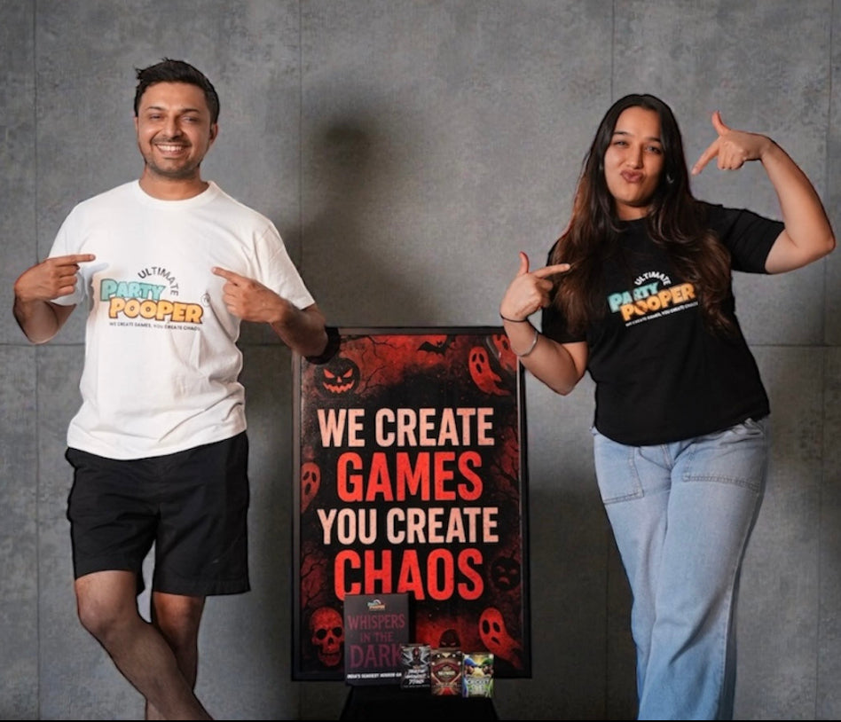 Two people posing with a sign that reads 'We create games, you create chaos' against a gray background.